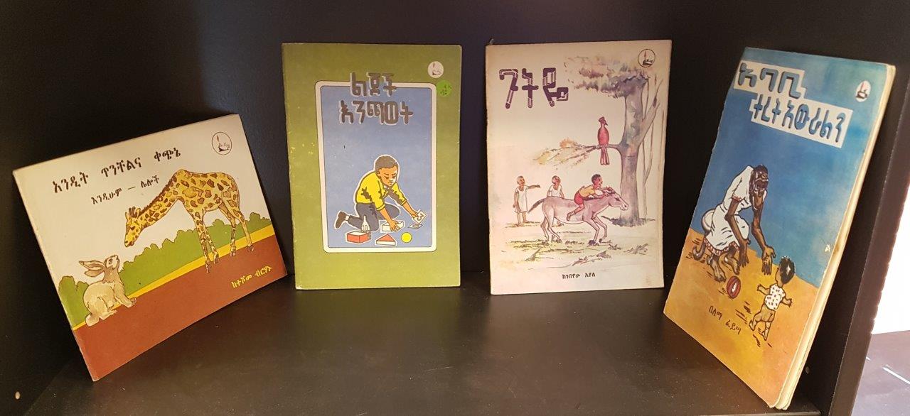 Photo of bookshelf with children's books in Amharic